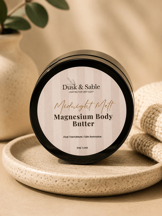 Midnight Ritual Magnesium Body Butter jar with black lid on textured beige tray.